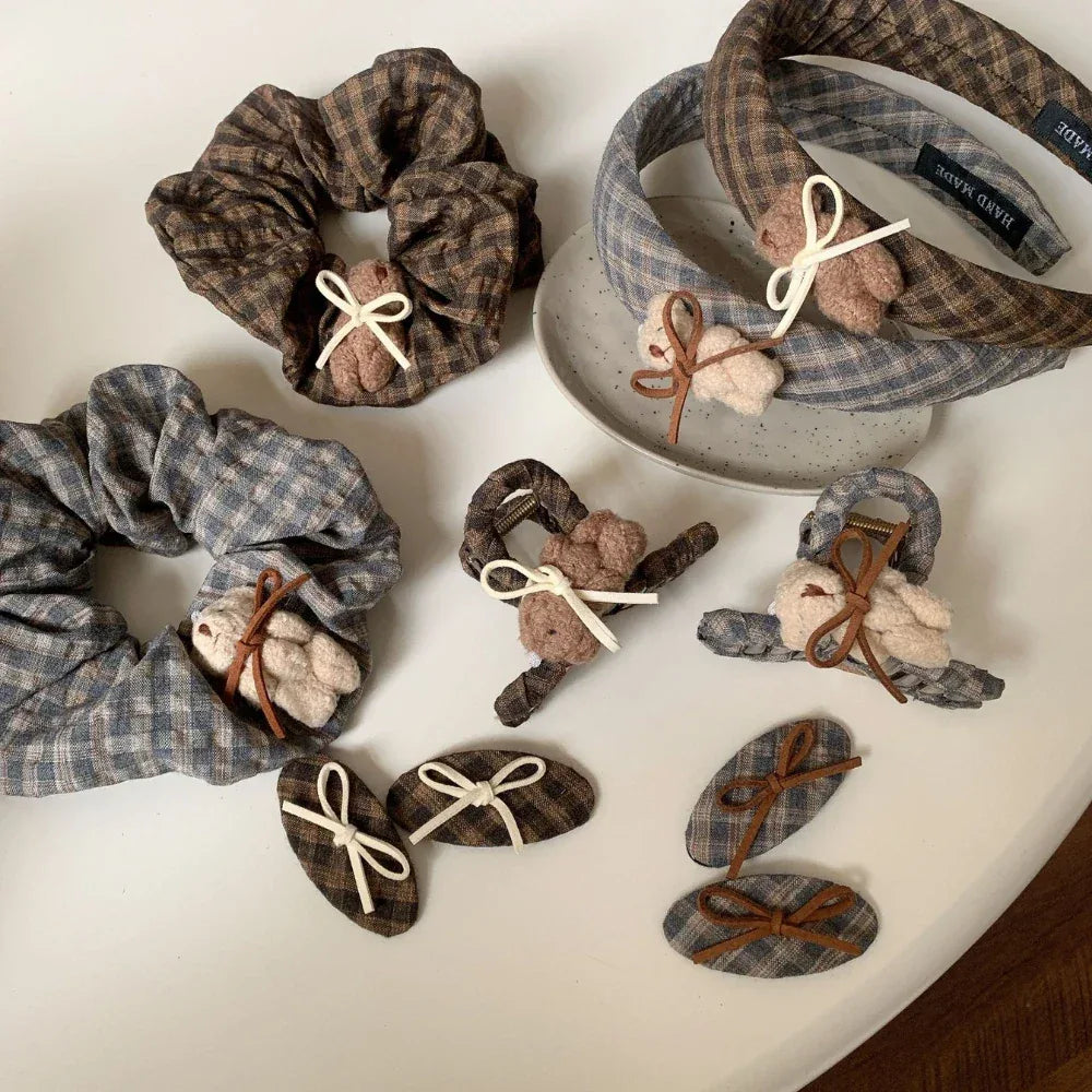 collection of plaid hair accessories including scrunchies, headbands, and clips with teddy bear and bow details