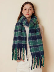 Woman wearing a green and navy plaid scarf draped around her neck, styled with a white top.