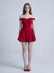 Woman in a red off-the-shoulder mini dress standing against a white background
