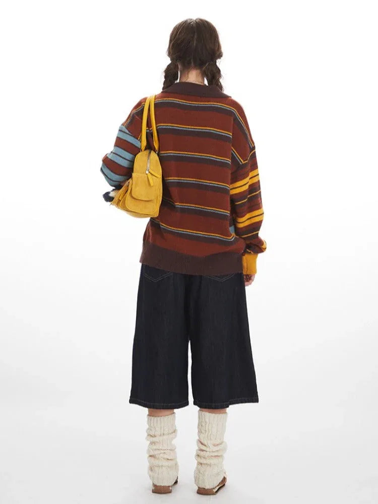 Back view of a woman wearing a striped knit cardigan with wide-leg dark denim pants and cream leg warmers, holding a yellow handbag.