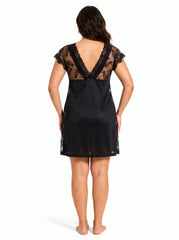 Woman wearing a black lace-trimmed chemise, back view