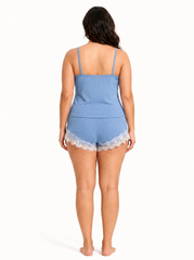 Woman wearing blue ribbed knit pajama shorts with white lace trim and a grey drawstring.