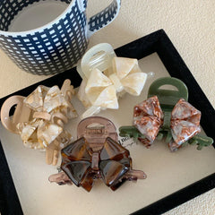 Collection of bow claw clips in various colors and marbled patterns
