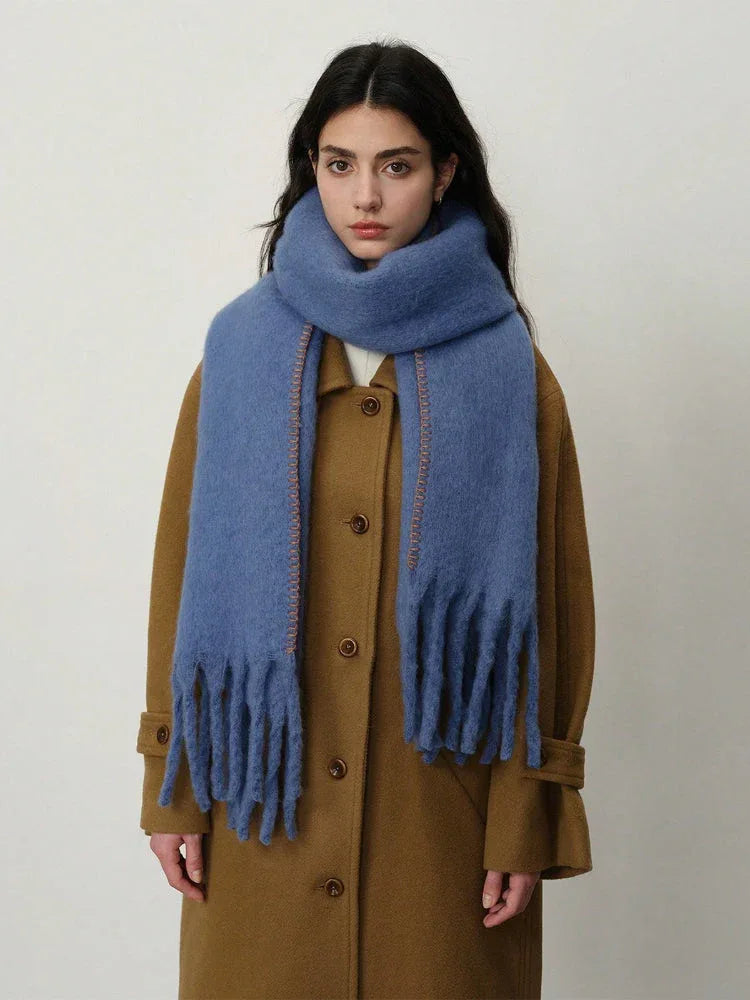 Front view of a woman wearing a blue scarf and a brown coat