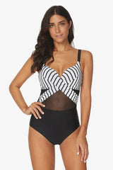 Woman wearing a black and white striped and black one-piece swimsuit with mesh detailing