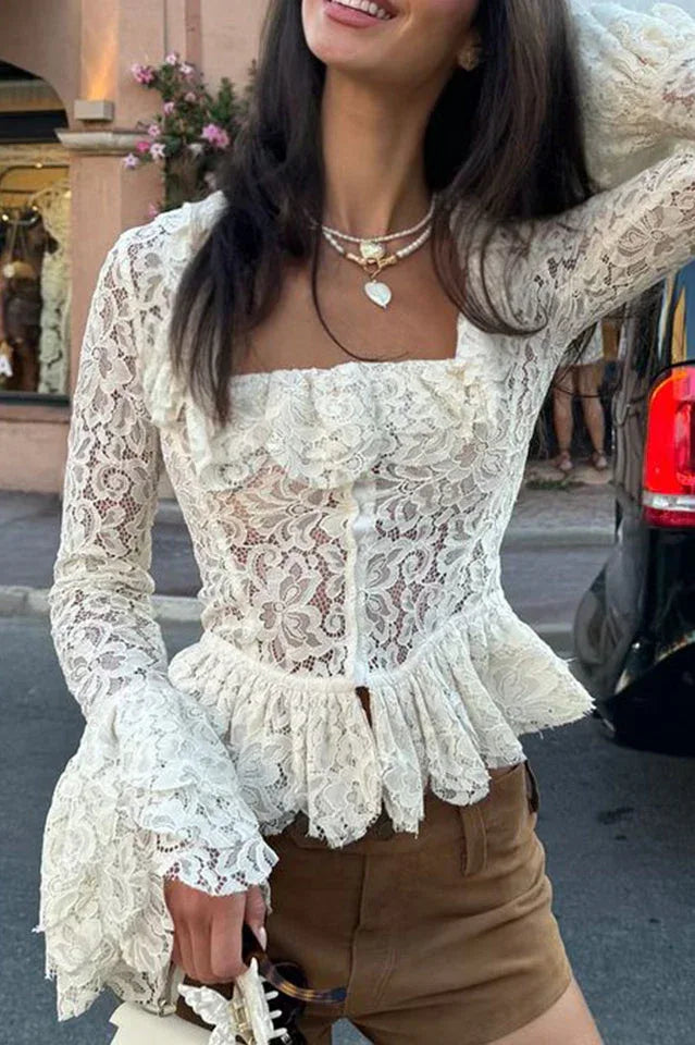 Close-up of a white lace peplum top with square neckline and ruffled trim.