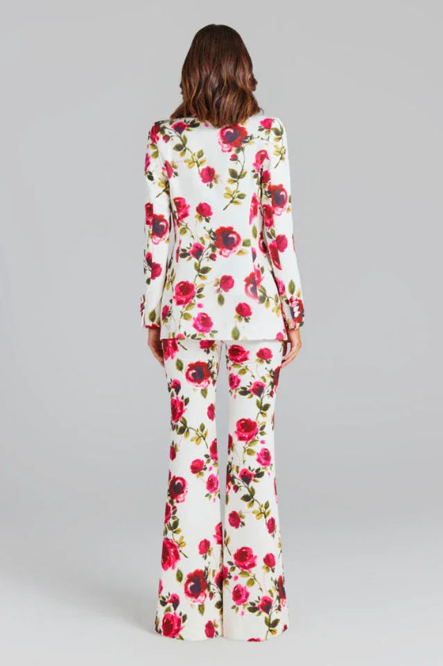 Rear view of a woman in a white floral print suit