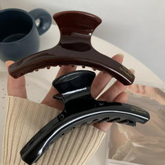 hand holding a brown and black hair claw clip