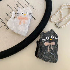 White and black marbled cat hair clips with pink bows