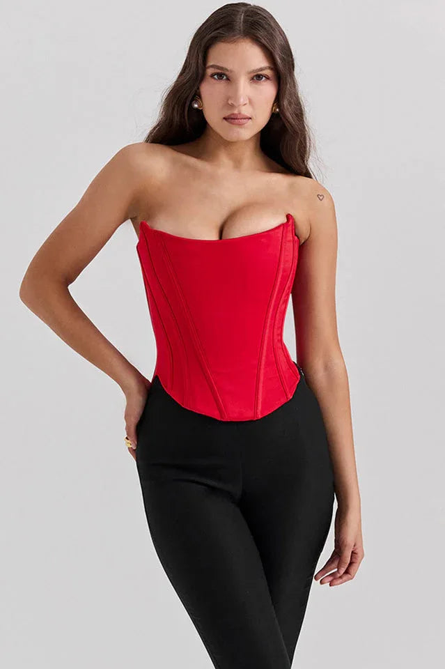 Three-quarter front view of a red strapless corset paired with black trousers.