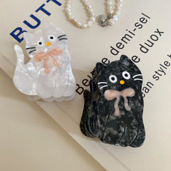 White and black marbled cat hair clips with pink bows and text background