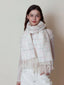 Woman wearing a white plaid scarf with pink and grey accents