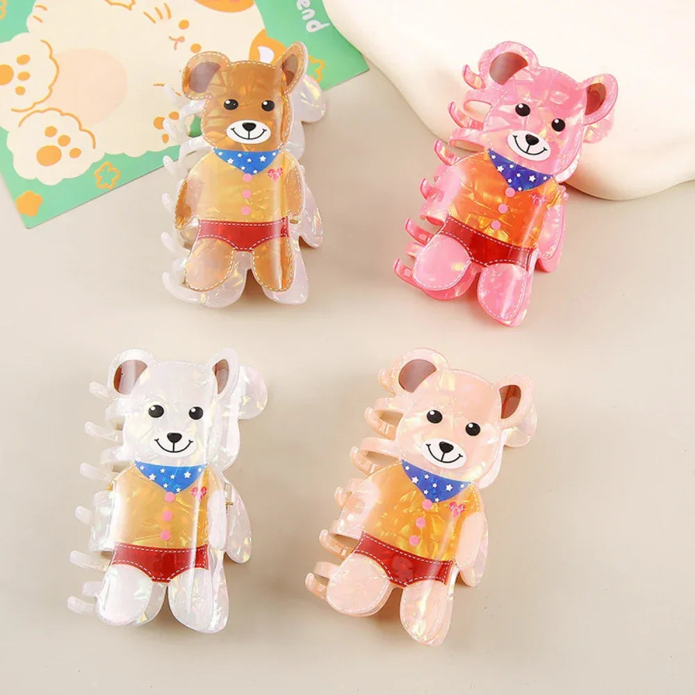 Collection of four iridescent bear-shaped hair claw clips in different colors (brown, pink, white, peach)