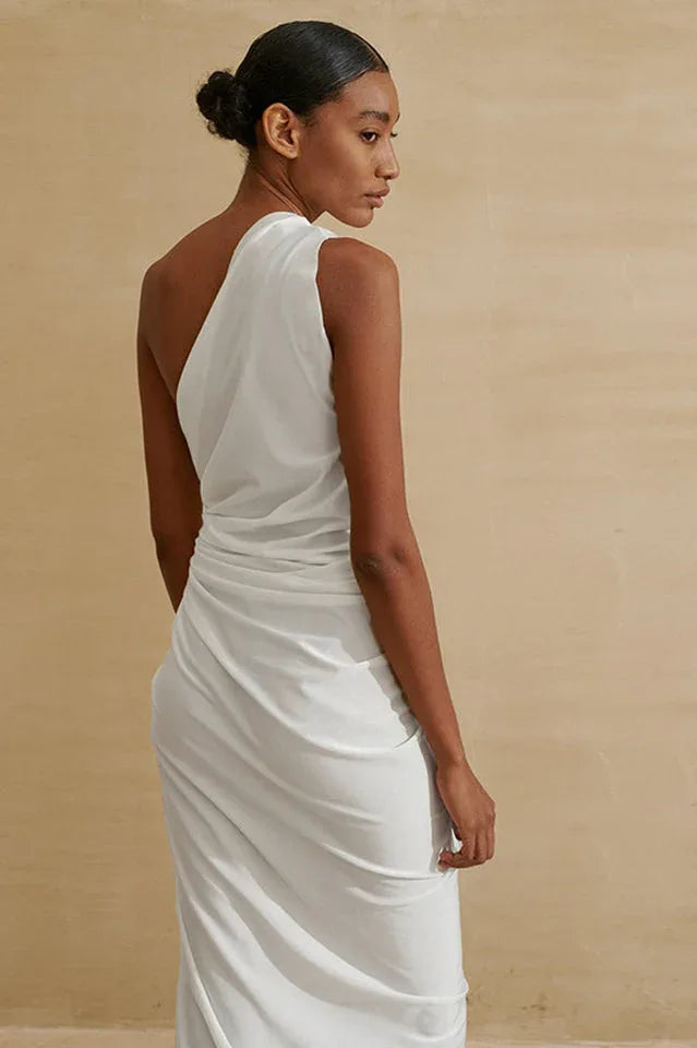Back view of a model in a white one-shoulder draped dress