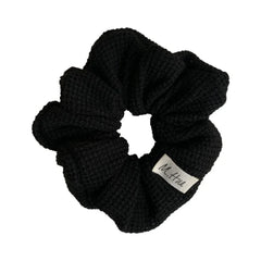 Black waffle knit scrunchie with a white brand tag