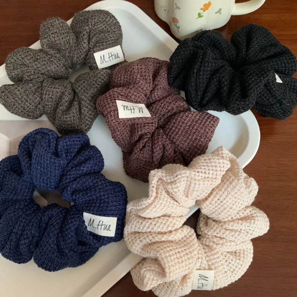 Overhead view of a set of waffle knit scrunchies in multiple colors