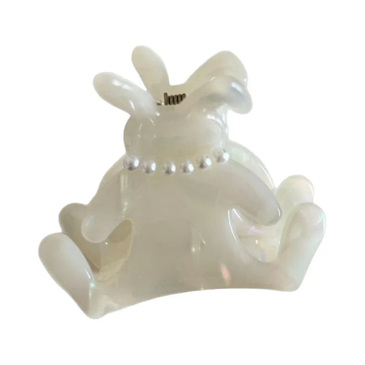 A white bunny-shaped hair claw clip with a pearl-beaded collar, isolated on a white background.