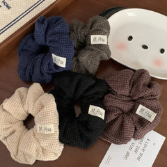Assortment of waffle knit scrunchies displayed on a wooden surface