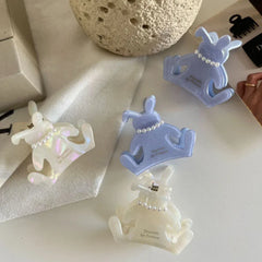 A collection of bunny-shaped hair claw clips in white and light purple, displayed on a white surface.