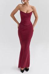 Woman wearing a deep red strapless ruched mesh gown with a sweetheart neckline and a fitted mermaid silhouette.