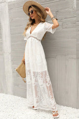 woman in a white lace maxi dress wearing a straw hat and holding a clutch