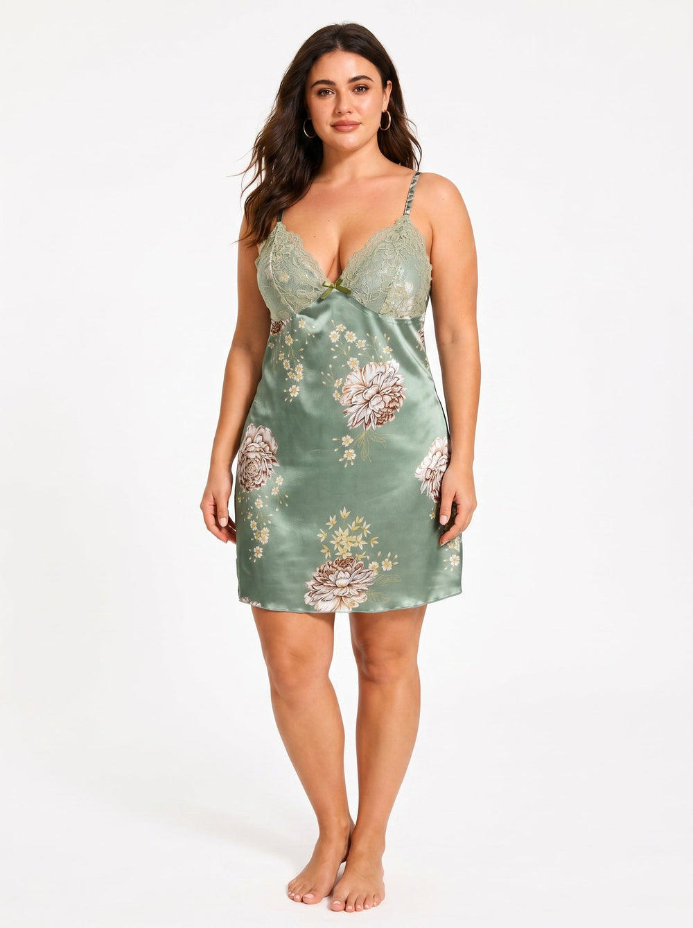 Front view of a plus-size model in a green satin chemise with a floral print and lace detail