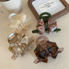 Four bow claw clips arranged in a square pattern