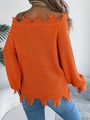 Back view of a woman wearing an orange distressed off-the-shoulder knit sweater with blue jeans.