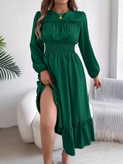 woman lifting the hem of a long green dress to show her leg