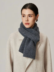 Woman wearing a grey knit scarf and a cream coat.
