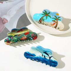 Three cloud-shaped hair claws arranged on a white surface, showcasing different scenic designs