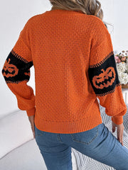 Back view of a woman wearing an orange and black pumpkin print knit sweater