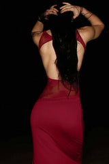 Back view of a woman in a floor-length red dress with an open back and lace detailing.