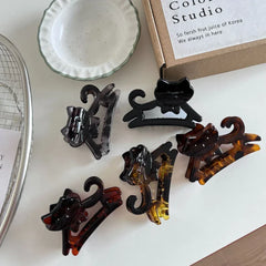 Several cat-shaped hair claw clips arranged on a white surface.