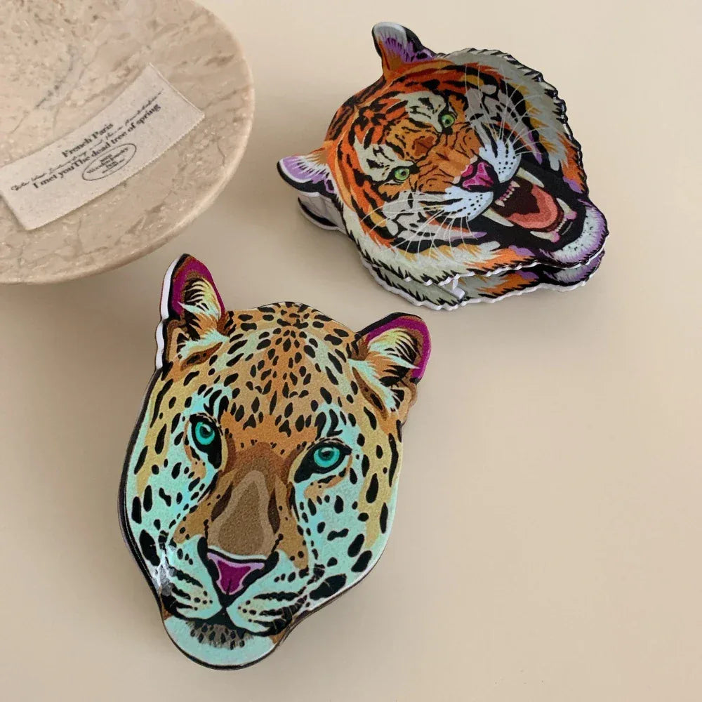 Overhead view of a leopard head accessory and a tiger head accessory on a decorative plate