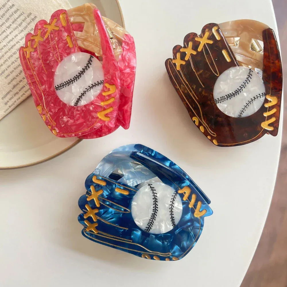 Arrangement of three marbled acrylic baseball glove hair claw clips on a white surface