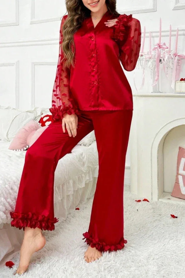 Full-length view of a woman in a red satin pajama set with sheer sleeves.