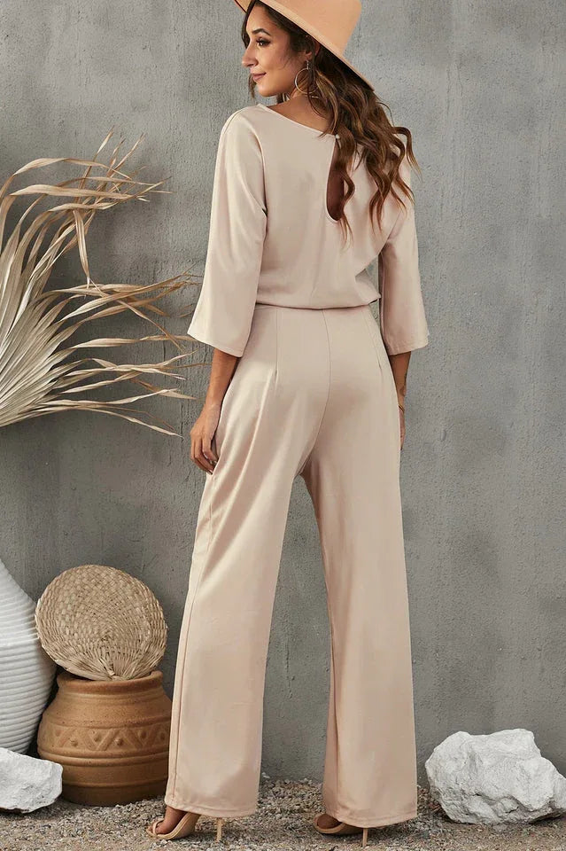back view of a beige wide leg jumpsuit with a tie waist and keyhole detail