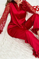 Close-up of a woman wearing a red satin pajama set.
