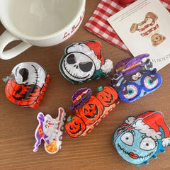 A close-up shot of assorted Halloween-themed hair clips scattered on a wooden surface.