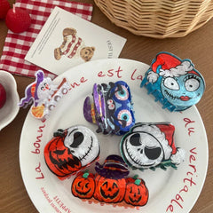 A collection of Halloween-themed hair clips arranged on a plate and a wooden surface.