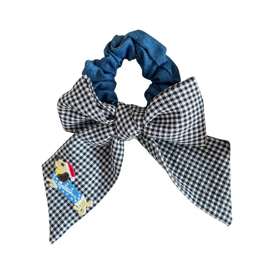 Black and white gingham scrunchie with a denim center and a large bow featuring a dog applique
