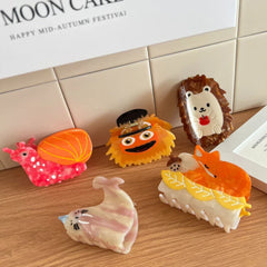 A variety of novelty hair clips including a hedgehog, snail, fox, seal, and a fuzzy character.