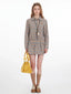 Model wearing a plaid shirt dress with a yellow handbag, front view