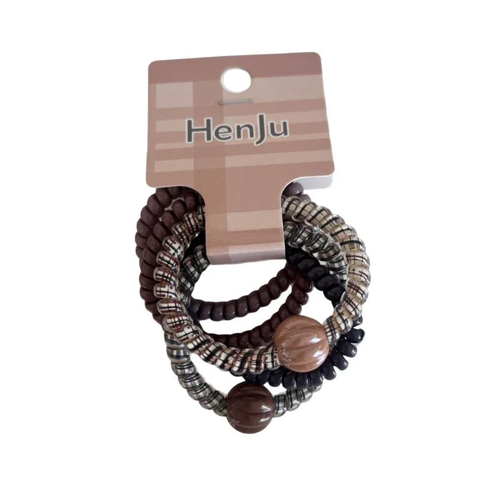 A close-up shot of a pack of spiral hair ties with brown beads.
