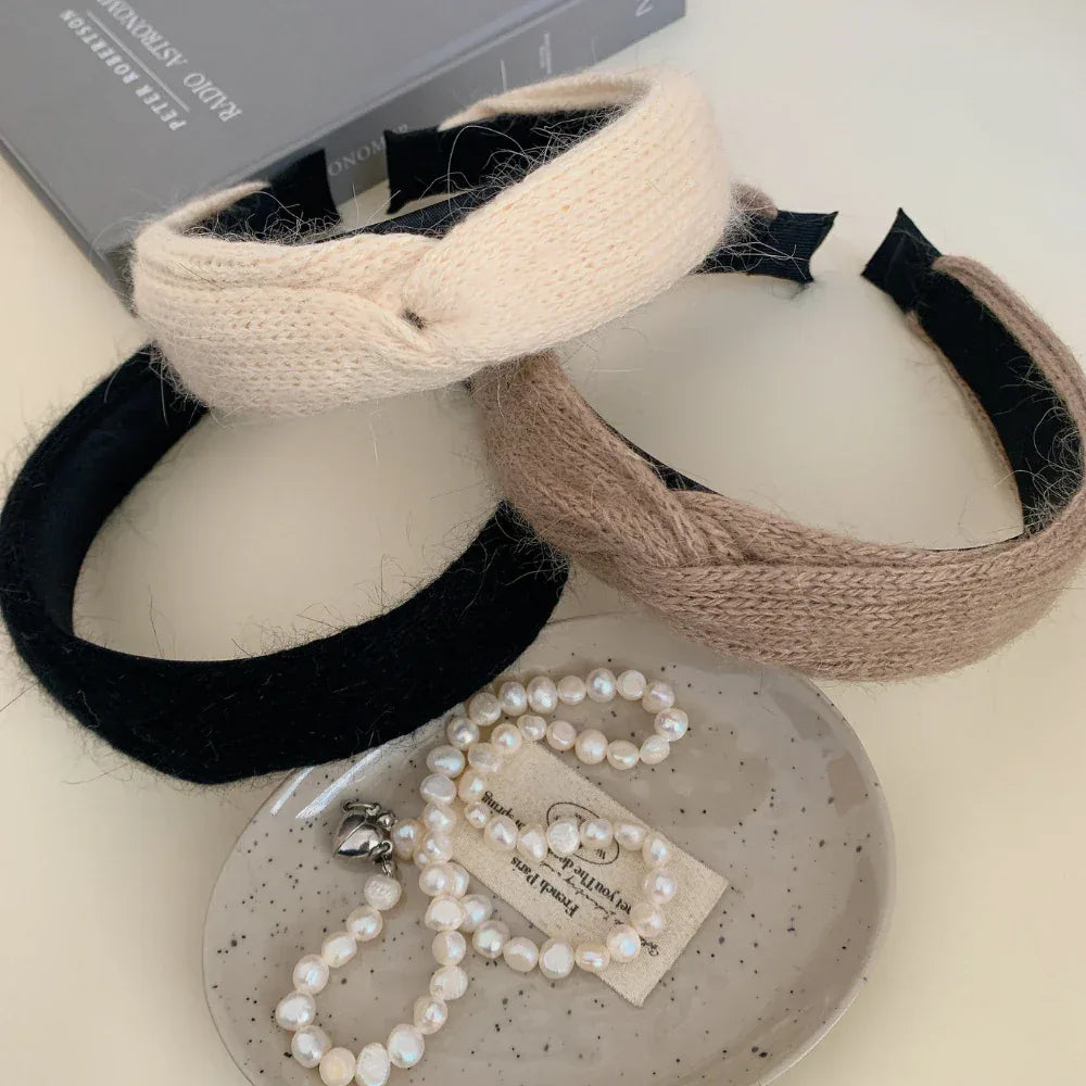Three knit headbands in cream, taupe, and black, with pearls and a book