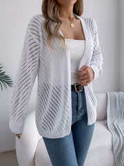 Close-up of a woman wearing a white open-knit cardigan, showing the texture and detail.