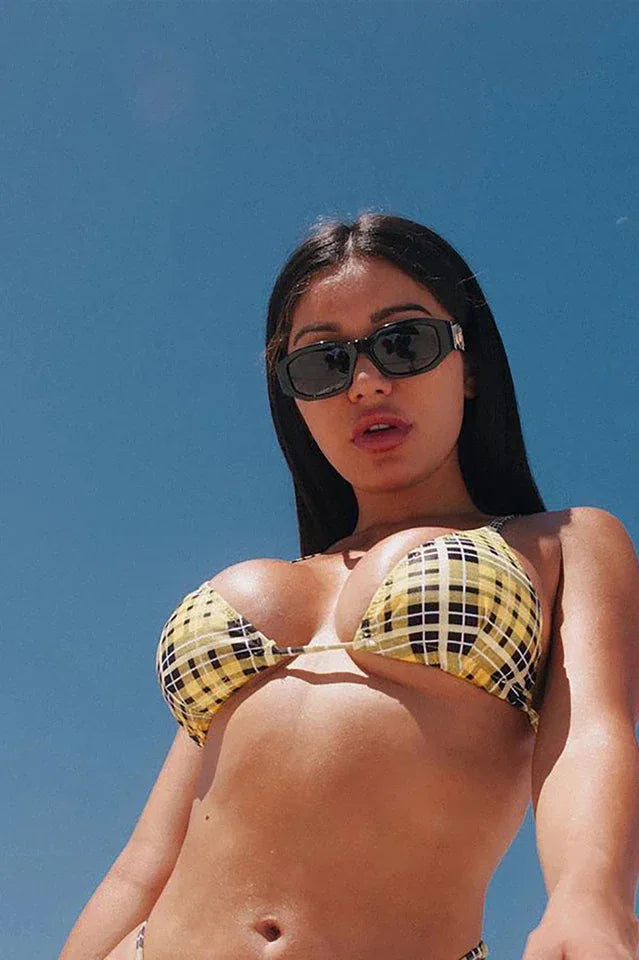 Woman wearing a yellow plaid bikini top from a low angle