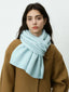 Close-up of a woman's face with a light blue scarf.