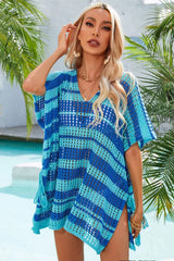 Woman wearing a blue and teal striped crocheted poncho with a V-neck and short sleeves by a pool.